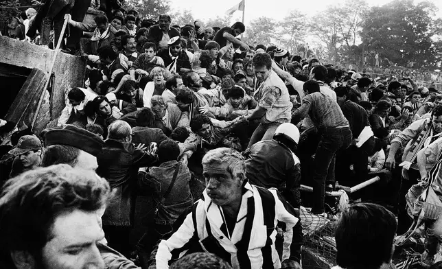 FILE - Soccer fans are crushed against a collapsing wall in the Brussels Heysel stadium just prior to the European Cup final soccer match between Liverpool and Juventus, in Brussels, Belgium, May 29, 1985. (AP Photo/Gianni Foggia, File)