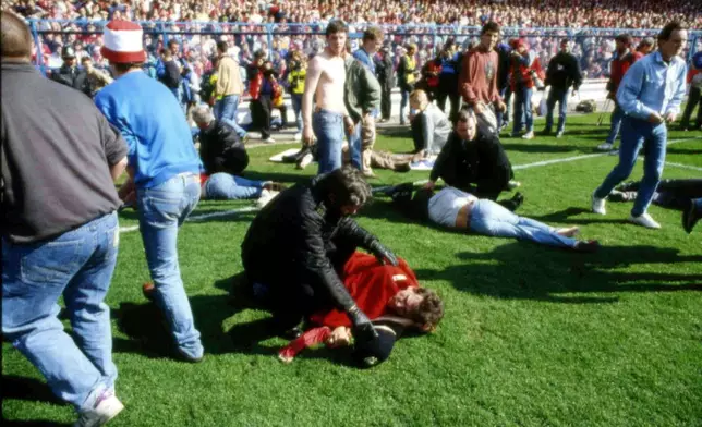 FILE - Stewards and supporters tend and care for wounded supporters on the field at Hillsborough Stadium, in Sheffield, England, April 15, 1989. (AP Photo, File)