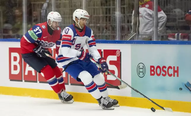 USA's Matty Beniers, right, and Norway's Markus Vikingstad, left, challenge for the puck during the group B match between USA and Norway at the IIHF Ice Hockey World Championships in Herning, Denmark, Wednesday, May 14, 2025. (Bo Amstrup/Ritzau Scanpix via AP)