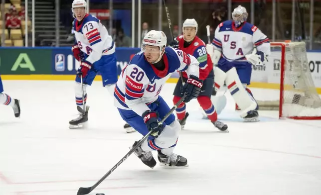 USA's Andrew Peeke, front, plays the puck during the group B match between USA and Norway at the IIHF Ice Hockey World Championships in Herning, Denmark, Wednesday, May 14, 2025. (Bo Amstrup/Ritzau Scanpix via AP)