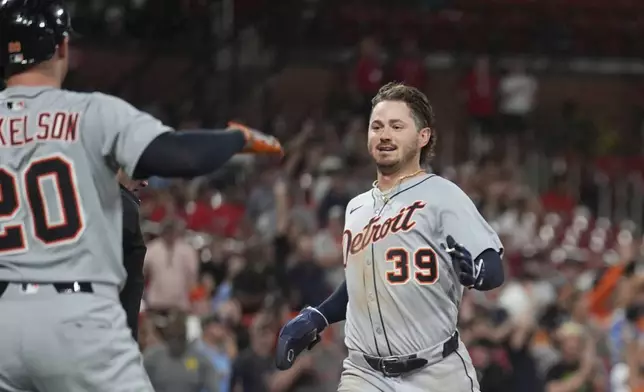 Detroit Tigers' Zach McKinstry (39) is congratulated by teammate Spencer Torkelson (20) after scoring during the ninth inning of a baseball game against the St. Louis Cardinals Tuesday, May 20, 2025, in St. Louis. (AP Photo/Jeff Roberson)