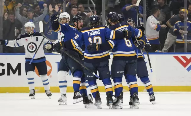 St. Louis Blues defenseman Philip Broberg (6) is congratulated by teammates after scoring a goal against the Winnipeg Jets during the first period in Game 6 of an NHL hockey first-round playoff series Friday, May 2, 2025, in St. Louis. (AP Photo/Jeff Le)
