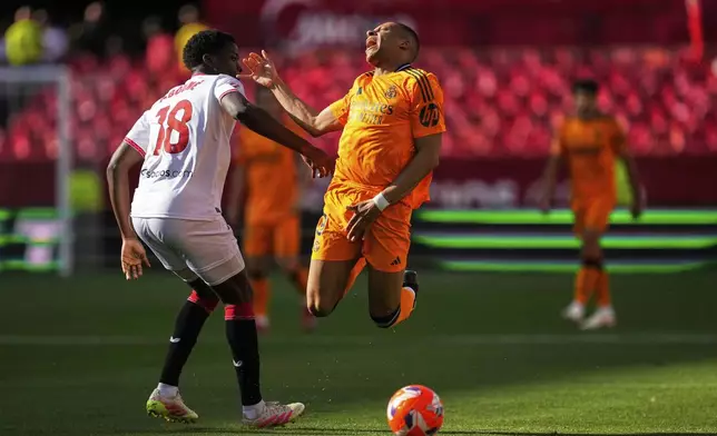 Sevilla's Lucien Agoume, left, in action against Real Madrid's Kylian Mbappe during a Spanish La Liga soccer match between Sevilla and Real Madrid at the Ramon Sanchez Pizjuan stadium in Seville, Spain, Sunday, May 18, 2025. (AP Photo/Jose Breton)