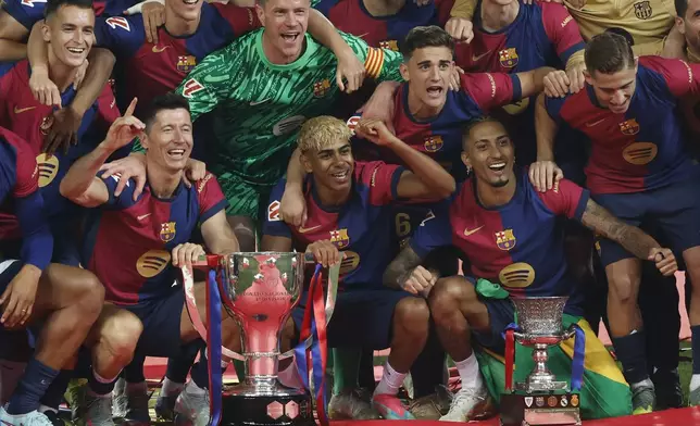 Bottom from left: Barcelona's Robert Lewandowski, Lamine Yamal and Raphinha celebrate with teammates as they won the La Liga after the Spanish La Liga soccer match between Barcelona and Villarreal at Lluis Companys Olympic Stadium in Barcelona, Spain, Sunday, May 18, 2025. (AP Photo/Joan Monfort)
