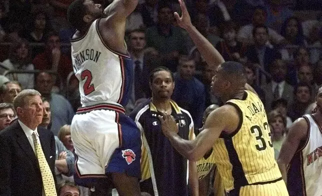 New York Knicks Larry Johnson (2) lets a three point shot go over Indiana Pacers Antonio Davis (33) during the final seconds of Game 3 of the Eastern Conference finals Saturday, June 5, 1999, at New York's Madison Square Garden. Johnson's basket was good and Davis fouled him on the play. Johnson hit his free throw with 5.7 second left to lift the Knicks to a stunning 92-91 victory. (AP Photo/Ron Frehm)