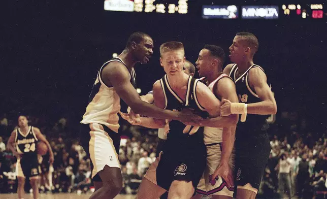 FILE - Indiana Pacers' Detlef Schrempf, center, is restrained by teammate LaSalle Thompson, left, as New York Knicks' John Starks, second from right, is sandwiched between the Pacers' Reggie Miller during a third period scuffle that began when Schrempf clashed with Knicks' Anthony Mason in New York's Madison Square Garden, March 15, 1993. The Knicks went on to a 121-90 win. (AP Photo/Bill Koustroun, File)