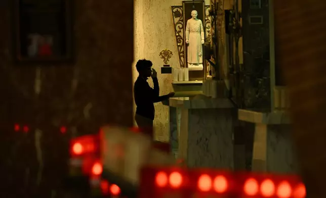 A St. Rita High School student prays in the school chapel where the new Pope Leo XIV, Chicago native Cardinal Robert Prevost, was a substitute teacher, Thursday, May 8, 2025, in Chicago. (AP Photo/Paul Beaty)