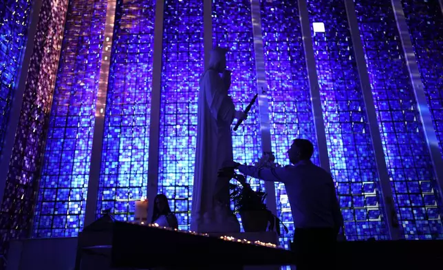Faithful pray in front of an image of Our Lady before a Mass to honor Robert Prevost, who was announced as Pope Leo XIV, at the Dom Bosco Sanctuary, in Brasilia, Brazil, Thursday, May 8, 2025. (AP Photo/Eraldo Peres)