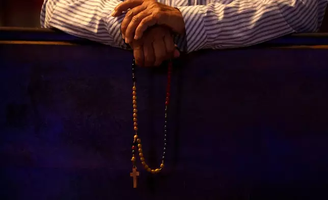 A parishioner holds with her Rosary during a Mass in honor of Robert Prevost, who was announced as Pope Leo XIV, at the Dom Bosco Sanctuary, in Brasilia, Brazil, Thursday, May 8, 2025. (AP Photo/Eraldo Peres)