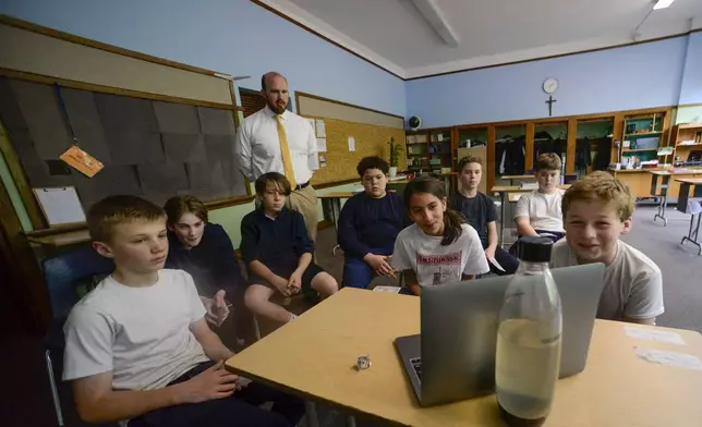 Students from St. Michael's Catholic School watch as Pope Leo XIV addresses the crowd at the Vatican on Thursday, May 8, 2025, in Brattleboro, Vt. (Kristopher Radder/The Brattleboro Reformer via AP)