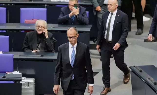 Friedrich Merz walks in the plenary after he failed to be elected new chancellor in the first voting process at the German federal parliament, Bundestag, at the Reichstag building in Berlin, Tuesday, May 6, 2025. (AP Photo/Markus Schreiber)