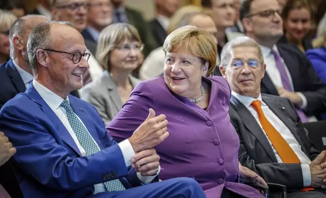 FILE - Former German Chancellor Angela Merkel and CDU Federal Chairman and CDU parliamentary group leader Friedrich Merz, left, take part in the Berlin special discussion on the former Chancellor's 70th birthday, in Berlin, Sept, 25, 2024. (Kay Nietfeld/dpa via AP)