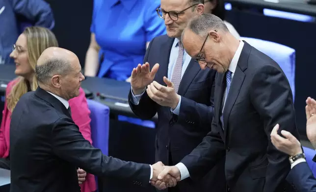 Leader of the Christian Democrats Friedrich Merz is congratulated by outgoing Chancellor Olaf Scholz after being elected new chancellor at the German federal parliament, Bundestag, at the Reichstag building in Berlin, Germany, Tuesday, May 6, 2025. (AP Photo/Ebrahim Noroozi)