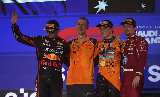 Race winner McLaren driver Oscar Piastri of Australia, second right, poses with second placed Red Bull driver Max Verstappen of the Netherlands, left, and third placed Ferrari driver Charles Leclerc of Monaco, right, after the Formula One Saudi Arabian Grand Prix at the Jeddah Corniche Circuit in Jeddah, Saudi Arabia, Sunday, April 20, 2025. (AP Photo/Altaf Qadri)
