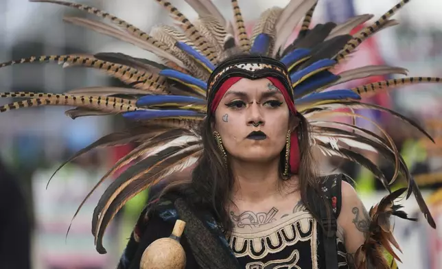 Jasmine Flores wears indigenous Mexican clothing as she and thousands of people march in a May Day rally and protest Thursday, May 1, 2025, in Chicago. (AP Photo/Erin Hooley)