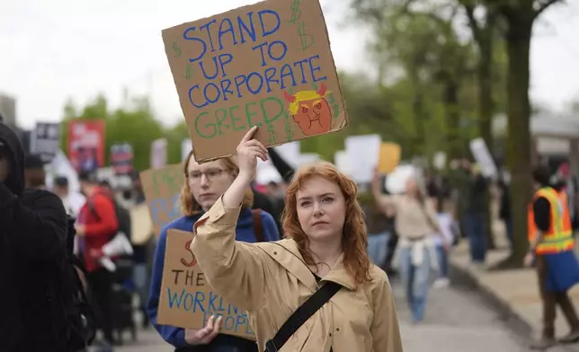 Claire Rockwell holds a sign as she and thousands of people march in a May Day rally and protest Thursday, May 1, 2025, in Chicago. (AP Photo/Erin Hooley)