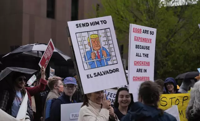 Protesters carry signs as thousands of people march in a May Day rally and protest Thursday, May 1, 2025, in Chicago. (AP Photo/Erin Hooley)