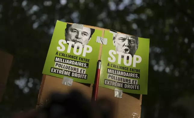 Protesters hold posters against Elon Musk, left, and President Donald Trump during the May Day demonstration, Thursday, May 1, 2025 in Paris. (AP Photo/Thibault Camus)