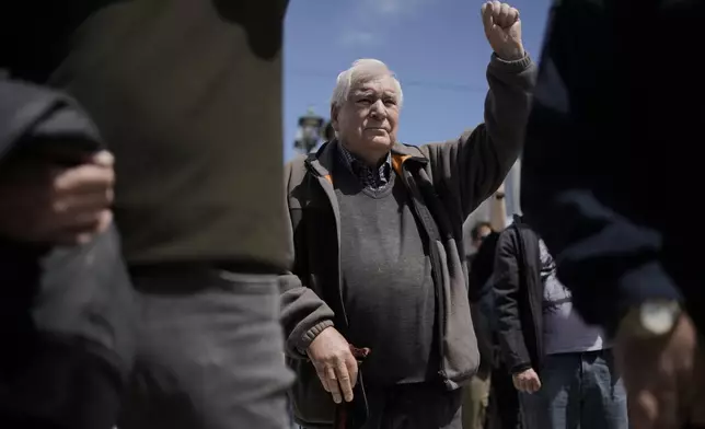 A protester raises his fist as he takes part in a rally organized by the communist party-affiliated PAME to mark May Day in Athens, Greece, Thursday, May 1, 2025. (AP Photo/Thanassis Stavrakis)