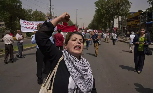 An Iraqi woman chants pro-worker slogans while supporters of the Iraqi Communist Party march during May Day celebration in Baghdad, Iraq, Thursday, May 1, 2025. (AP Photo/Hadi Mizban)