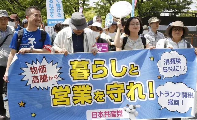 Peoeple march through the streets to mark May Day in Tokyo Thursday, May 1, 2025. A banner reads "Protect life and business." (AP Photo/Yuri Kageyama)