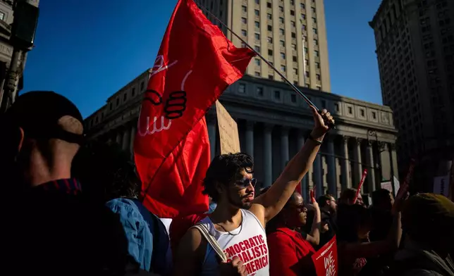 Alex Rivera holds up a pro-socialism flag during the NYCLU's May Day rally for worker's and immigrant's rights at Foley Square, Thursday, May 1, 2025, in New York. (AP Photo/Angelina Katsanis)