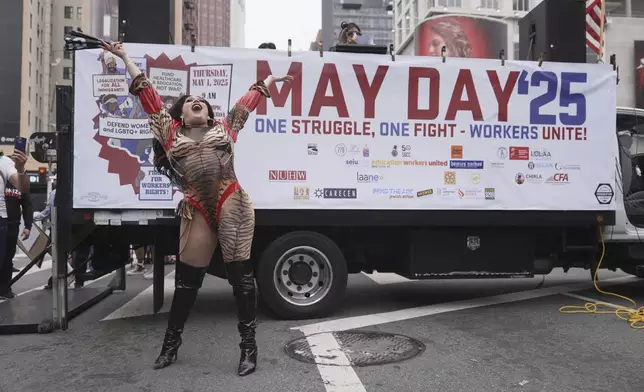 A demonstrator stands in front of a sign during a May Day protest Thursday, May 1, 2025, in Los Angeles. (AP Photo/Jae C. Hong)