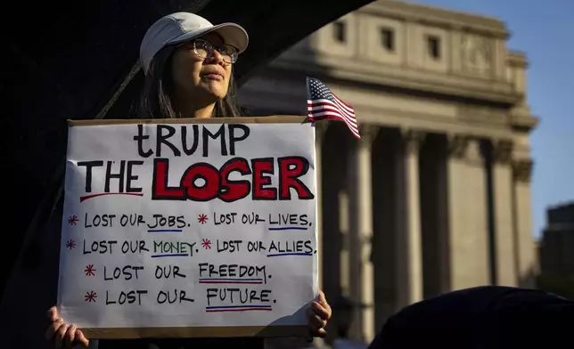 Cindy Leung holds a sign protesting President Donald Trump at the NYCLU's May Day rally for worker's and immigrants rights at Foley Square, Thursday, May 1, 2025, in New York. (AP Photo/Angelina Katsanis)