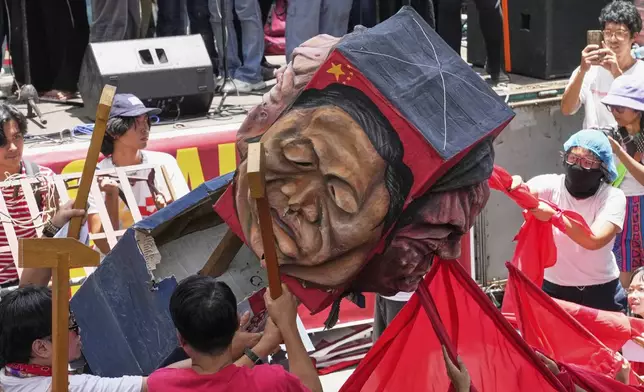 Activists and workers hit a figure of Chinese President Xi Jinping during a May Day rally in Manila, Philippines, Thursday, May 1, 2025. (AP Photo/Aaron Favila)