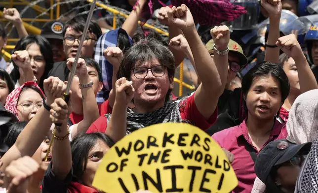 Activist and workers raise their clenched fists during a May Day rally in Manila, Philippines, Thursday, May 1, 2025. (AP Photo/Aaron Favila)