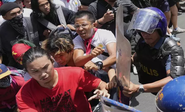 Activists and workers scuffle with police as they tried to march towards the presidential palace during a May Day rally in Manila, Philippines on Thursday, May 1, 2025. (AP Photo/Aaron Favila)