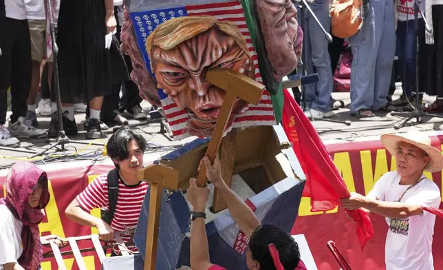 Activists and workers hit a figure of US President Donald Trump during a May Day rally in Manila, Philippines, Thursday, May 1, 2025. (AP Photo/Aaron Favila)