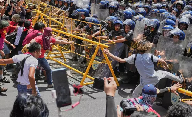 Activists and workers scuffle briefly with police as they tried to remove the barricades during a May Day rally near the Malacanang presidential palace in Manila, Philippines on Thursday, May 1, 2025. (AP Photo/Aaron Favila)