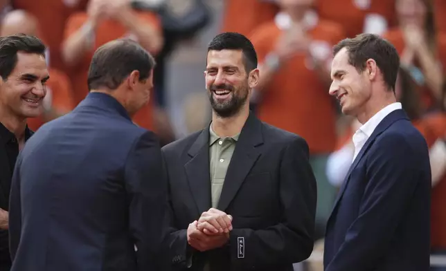 Rafa Nadal, second from left, is joined by Roger Federer, left, Novak Djokovic and Andy Murray, right, during a farewell ceremony at center court Philippe-Chatrier, at the Roland-Garros stadium, in Paris, Sunday May 25, 2025. (AP Photo/Lindsey Wasson)