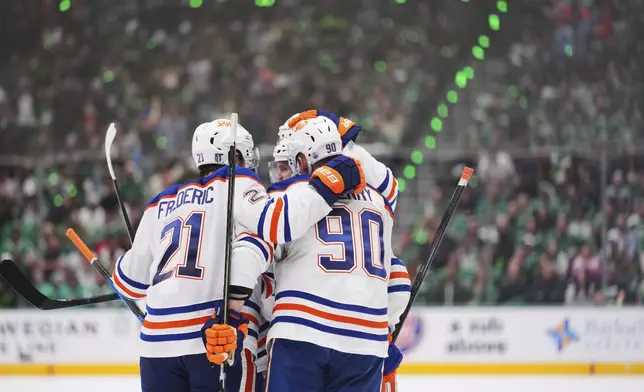 Edmonton Oilers players celebrate after center Connor McDavid (97) scored against the Dallas Stars during the second period of Game 5 of the Western Conference finals in the NHL hockey Stanley Cup playoffs, Thursday, May 29, 2025, in Dallas. (AP Photo/Julio Cortez)