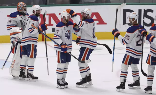Edmonton Oilers players celebrate after winning Game 5 of the Western Conference finals in the NHL hockey Stanley Cup playoffs against the Dallas Stars, Thursday, May 29, 2025, in Dallas. (AP Photo/Gareth Patterson)