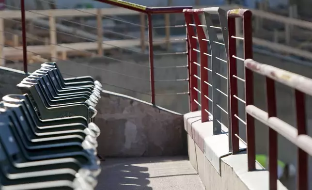 FILE - Current railings, far right, stand in front of the outfield stands at Rangers Ballpark in Arlington are 36 1/4 inches in front of the seats and 42 inches tall at the end of each isle, will be raised to a uniform 42 inches as renovations continue, Thursday, Jan. 5, 2012, in Arlington, Texas. The Ranges moved into a new ballpark in 2020. (AP Photo/Brandon Wade, File)