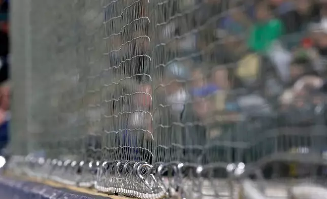 FILE - Newly installed netting at Safeco Field designed to protect fans from foul balls and flying bats is shown above the visitors' dugout during a baseball game between the Seattle Mariners and the Cleveland Indians, Thursday, March 29, 2018, in Seattle. (AP Photo/Ted S. Warren, File)