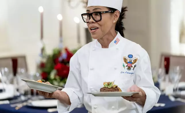 FILE - White House executive chef Cris Comerford, holds dishes as she speaks during a media preview for the State Dinner with President Joe Biden and French President Emmanuel Macron in the State Dining Room of the White House in Washington, Nov. 30, 2022. (AP Photo/Andrew Harnik, File)