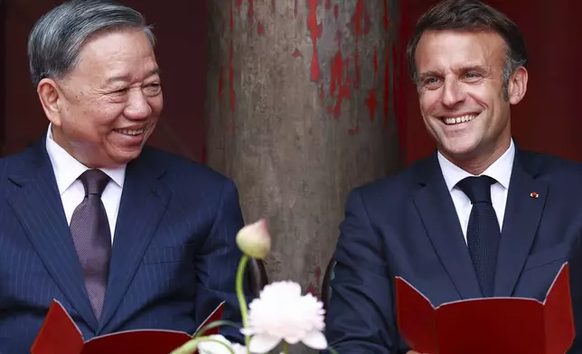 French President Emmanuel Macron, right, attends a luncheon with Vietnam's Communist Party General Secretary To Lam at Van Mieu, in Hanoi, Vietnam, Monday May 26, 2025. (Chalinee Thirasupa/Pool via AP)