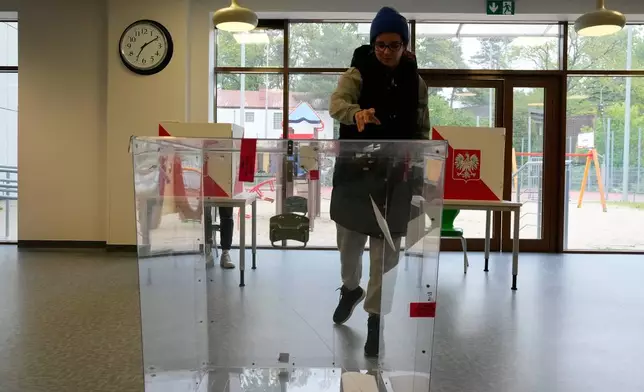 A voter casts a ballot shortly after polling stations opened in the first round of Poland's presidential elections in Łomianki, near Warsaw, on Sunday, May 18, 2025. (AP Photo/Czarek Sokolowski)
