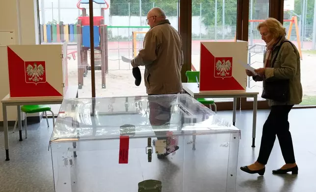 Voters cast their ballots shortly after polling stations opened in the first round of Poland's presidential elections in Łomianki, near Warsaw, on Sunday, May 18, 2025. (AP Photo/Czarek Sokolowski)