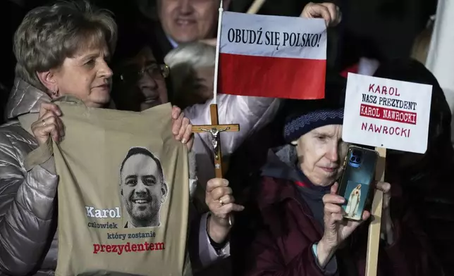 Supporters of conservative presidential candidate Karol Nawrocki hold up signs as they rally in Warsaw, Poland, Tuesday, May 13, 2025. The writing reads: Karol, the man who will become president, Wake up, Poland! and Our president Karol Nawrocki. (AP Photo/Czarek Sokolowski)