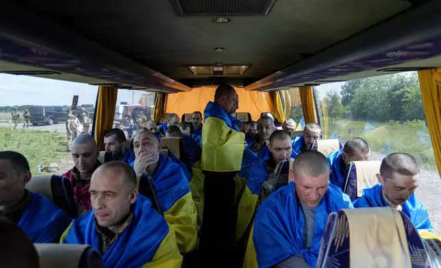 FILE - Ukrainian soldiers sit in a bus in the Sumy region of Ukraine after returning from captivity in Russia, May 31, 2024. (AP Photo/Evgeniy Maloletka, File)