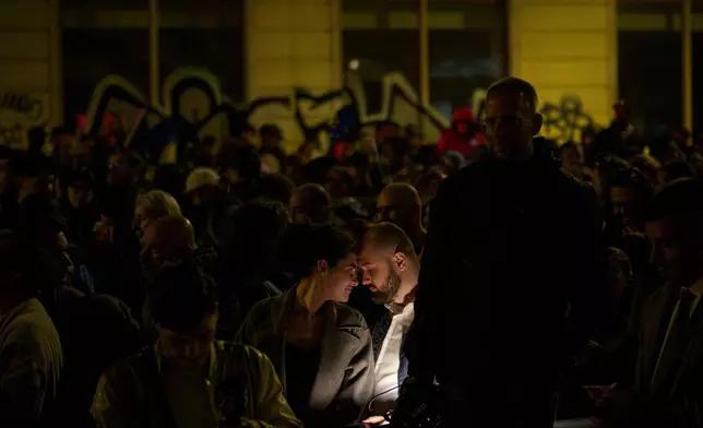 Supporters of presidential candidate Nicusor Dan touch foreheads after polls closed for the second round of the country's presidential election redo in Bucharest, Romania, Sunday, May 18, 2025. (AP Photo/Andreea Alexandru)