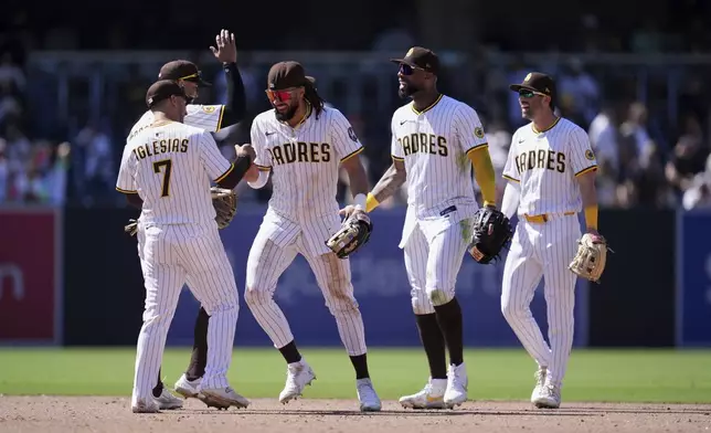 San Diego Padres right fielder Fernando Tatis Jr., center, celebrates with teammates after the Padres defeated the San Francisco Giants 5-3 in a baseball game Wednesday, April 30, 2025, in San Diego. (AP Photo/Gregory Bull)