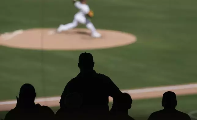 Fans look on as San Diego Padres relief pitcher Jeremiah Estrada works against a San Francisco Giants batter during the sixth inning of a baseball game Wednesday, April 30, 2025, in San Diego. (AP Photo/Gregory Bull)