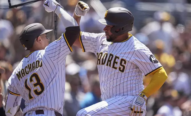 San Diego Padres' Elias Diaz, right, celebrates with teammate Manny Machado after hitting a home run during the third inning of a baseball game against the San Francisco Giants Wednesday, April 30, 2025, in San Diego. (AP Photo/Gregory Bull)