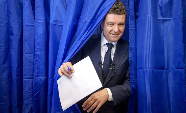 Presidential candidate Nicusor Dan exits a voting booth before casting his vote in the first round of the presidential election redo in Bucharest, Romania, Sunday, May 4, 2025. (AP Photo/Andreea Alexandru)