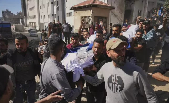 The body of Palestinian journalist Yahya Sobeih, center, who was killed along with at least 28 others in an Israeli army strike on a restaurant, is carried at Shifa hospital in Gaza City, Wednesday, May 7, 2025.(AP Photo/Jehad Alshrafi)